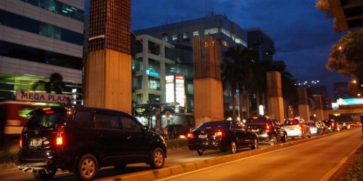 Cars crawl past unfinished support columns of the monorail project, which was canceled in 2008, along Jl. Rasuna Said in South Jakarta on Oct. 18, 2010.