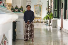 An 'abdi dalem' (royal servant) poses for a picture in traditional Javanese clothing at the Kraton Sultan Palace, Yogyakarta.