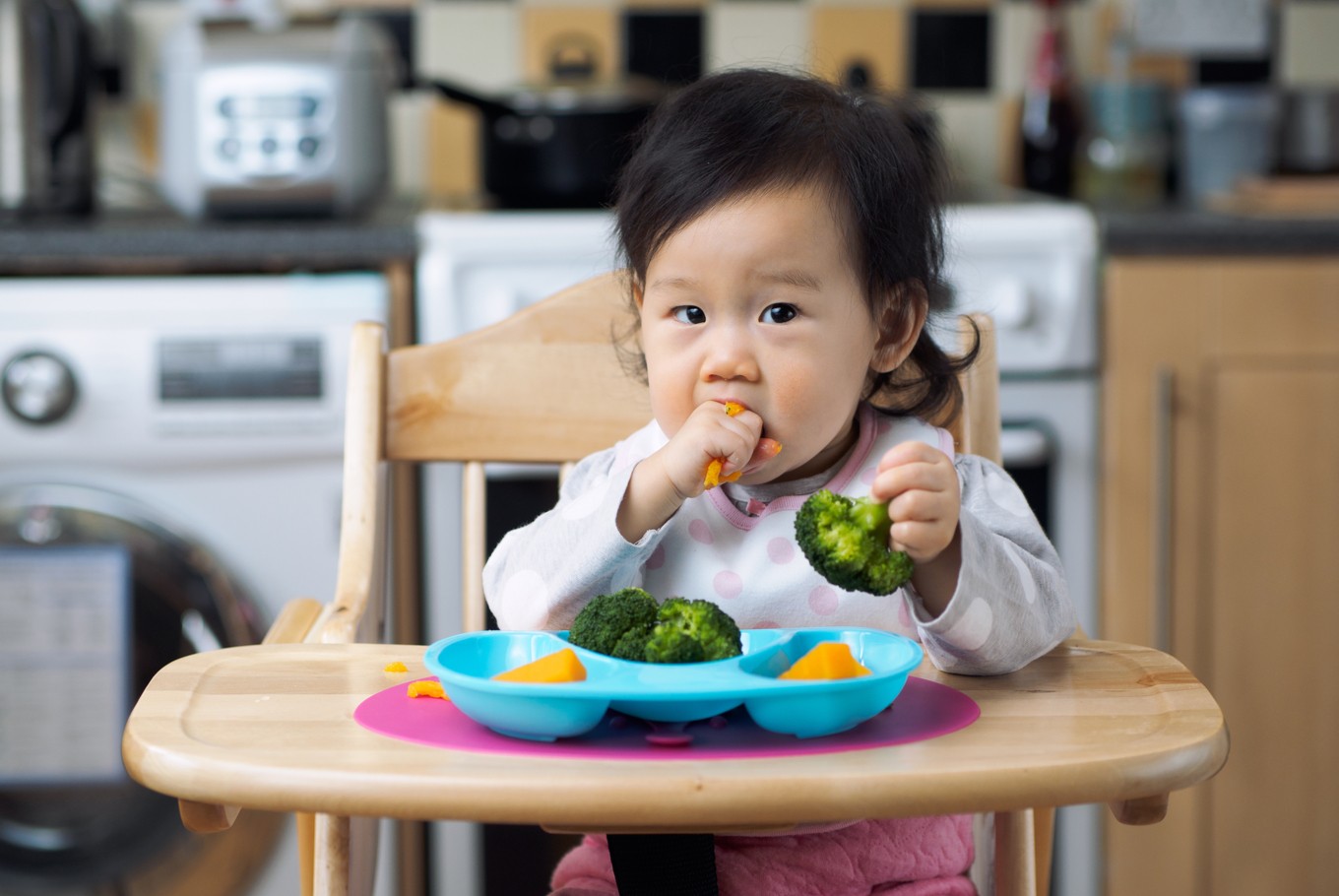 Asian baby boy 6 months old eating with Baby Led Weaning (BLW