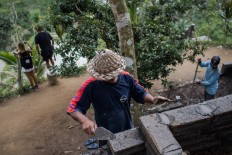 On progress: Wayan Arnawa (center) builds a simple kitchen around the paddy field tourist site in Ceking. JP/ Anggara Mahendra
