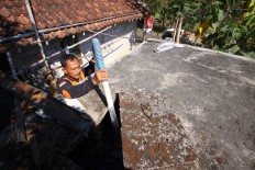 A staff of the Regional Disaster Management Agency (BPBD) of Gunungkidul regency distributes clean water by using a mobile tank at a shelter of Semugih village in Gunungkidul, Yogyakarta. JP/Aditya Sagita