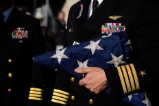 Navy Captain William Sherrod holds a flag from the USS Somerset to present to family members of the the victims at the Flight 93 National Memorial on the 16th Anniversary ceremony of the September 11th terrorist attacks, September 11, 2017 in Shanksville, Pennsylvania. United Airlines Flight 93 crashed into a field outside Shanksville, PA with 40 passengers and 4 hijackers aboard on September 11, 2001. AFP /Getty Images/Jeff Swensen