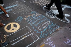 High school students draw the Twin Towers and write messages on the sidewalk in front of their school on September 11, 2017 in New York, in observance of 16th anniversary of the September 11, 2001 attacks. The attack, deadliest ever on US soil, killed 2,997 people, and plunged the United States into a chain of rolling wars against Islamic militants.  AFP/ Jewel Samad