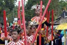 Some children join the 700-meter parade by walking on bamboo stilts at the eigth year of "Egrang" Festival (Sewindu Festival Egrang) in Jember.