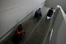 Three athletes maneuver their wheelchairs up a special ramp at the NPC Indonesia Office in
Surakarta, Central Java. JP/Maksum Nur Fauzan