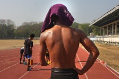 Track-and- field athlete Rijal Bagus, covers his head from the scorching sun on the track at the national training center in Surakarta, Central Java, during the lead-up to the 2017 ASEAN Para Games. JP/Maksum Nur Fauzan