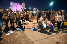 People tend to the wounded outside the Route 91 Harvest Country music festival grounds after an apparent shooting on October 1, 2017 in Las Vegas, Nevada. There are reports of an active shooter around the Mandalay Bay Resort and Casino. AFP/Getty Images/David Becker