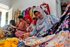 See and touch: Customers take a closer look at some batik cloths at Sekar Purnama Gallery. JP/Ibrahim Irsyad