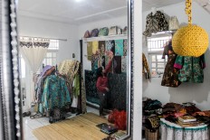 Humble beginnings: A batik artisan tidies up the ready-to- sell batik cloths that on display at the gallery. JP/Ibrahim Irsyad