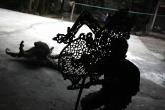 The silhouette of a craftman completing the puppets making. JP/Maksum Nur Fauzan