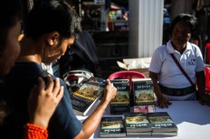 Visitors look at Luka Bom Bali (Wounds of the Bali Bombings) book at Ground Zero. JP/Anggara Mahendra