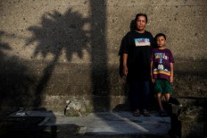 Chusnul and his son, Muafa, pose during the 15th anniversary of the Bali bombings at Ground Zero. JP/Anggara Mahendra