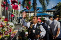 Agus Bambang Priyanto throws red rose petals at the Ground Zero Monument during a commemoration of the 15th anniversary of the Bali bombings. JP/Anggara Mahendra