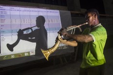 Perfect reflection: A trumpet player poses in front of a projector screen. JP/ Tarko Sudiarno
