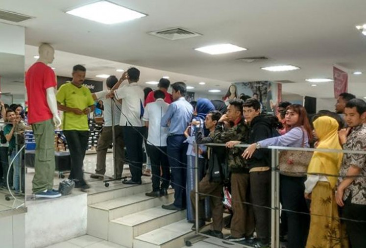 People queue in front a Lotus Department Store outlet in Jakarta on Oct 25 to buy goods with discounted prices after PT Mitra Adiperkasa announced its plans to close three outlets.