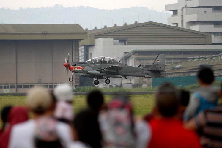Visitors watch a Super Tucano aircraft land at Husein Sastranegara Air Force Base in this undated photograph. JP/Arya Dipa