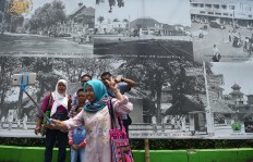 A family takes a selfie with a picture of old Malang in the background during the 2017 festival. JP/Aman Rochman