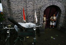 Two children wearing old soldier uniforms stand in front of a replica of Malang Fortress at the 2011 festival. JP/Aman Rochman