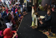 Visitors wearing traditional clothes use their mobile phones to record a performance by a leather puppet performer at the 2017 Malang Tempo Doeloe Festival on Nov. 12. 2017. JP/Aman Rochman
