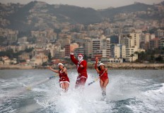 Members of a Lebanese water ski club perform while dressed in Santa Clause outfits in the bay of Jounieh on December 22, 2017. AFP/Patrick Baz