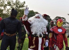 People dressed as (L-R) Batman, Santa Claus and Iron Man   walk at the presidential palace in Abidjan on December 23, 2017, during a Christmas event organised by the Children of Africa Foundation. The event, organised by Ivory Coast's first lady and president of the Children of Africa Foundation, welcomed 3000 children from Abidjan and Agboville. AFP/Sia Kambou