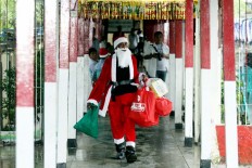 Ho, ho, ho: An inmate wearing a Santa Claus costume brings gifts to Kerobokan Prison in Denpasar, Bali. JP/Zul Trio Anggono