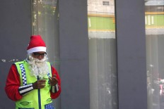 Dressed as Santa Claus, Marthins Hidungoran normally prays before he voluntarily directs traffic in Surakarta, Central Java, on Christmas Day. JP/Maksum Nur Fauzan