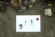Strange bedfellows: A cigarette, a bottle of medicine, a pipette and a plastic ball collected on Kuta Beach. JP/Agung Parameswara.
