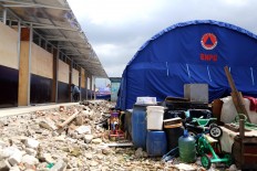 Workers complete a shelter in Kampung Akuarium, North Jakarta, on Jan. 29, 2018. 