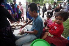 A volunteer serves a portion of white rice for the free meal. JP/ Boy T. Harjanto