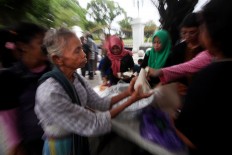An elderly woman receives her free meal. JP/ Boy T. Harjanto