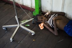 A Papuan girl on a drip lies on the bare floor of a local hospital handling measles and malnutrition patients in Agats, the capital of Asmat district in Indonesia's easternmost Papua province, on January 25, 2018. Some 800 children have been sickened by a measles-and-malnutrition outbreak in Indonesia's remote Papua province, officials said January 25, with as many as 100 people, mostly toddlers, feared to have been killed in the outbreak. AFP/ Bay Ismoyo