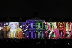People watch images from video mapping reflected on the wall of Fatahillah Museum in Kota Tua, Central Jakarta, as Indonesia and Japan comemmorate 60 years of bilateral relations on Friday, January. 19. The event was attended by Japanese special envoy Toshihiro Nikai. JP/Ben Latuihamallo
