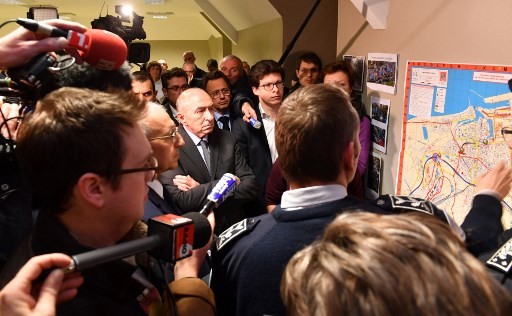 French Interior Minister Gerard Collomb (central) listens to a briefing at the Calais police station on Feb. 2 in Calais, northern France, following a large brawl between a hundred migrants which resulted in several injuries. Five migrants were in critical condition Thursday after being shot and 18 were injured in clashes in Calais between Afghans and Africans, local authorities said. Four Eritreans aged between 16 and 18 were taken to hospital for surgery, local prosecutors said. Another wounded migrant was taken to the nearby city of Lille because of his