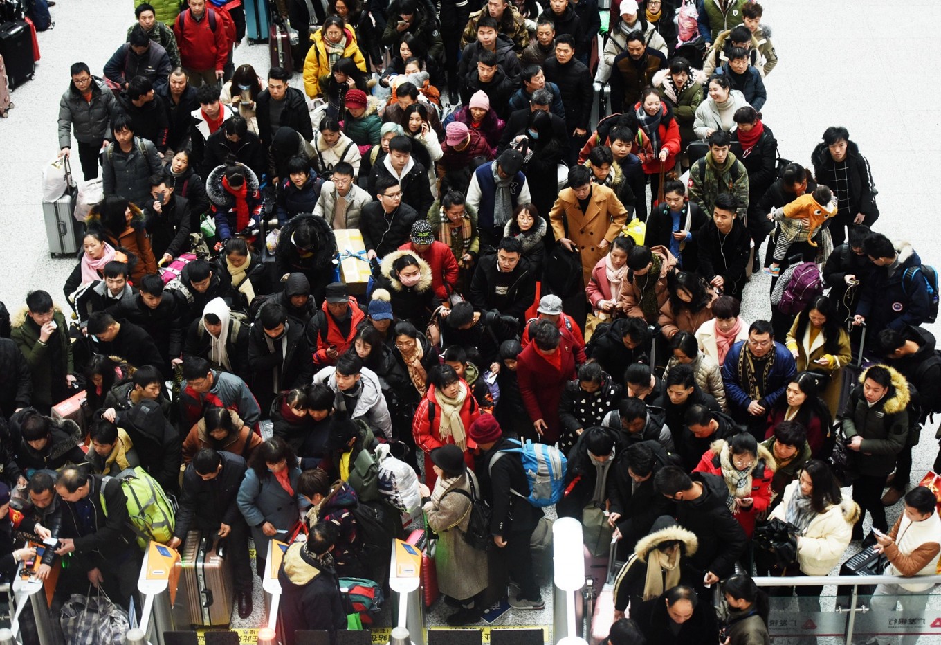 Passengers queue up to board trains at Hangzhou East Railway Station in Hangzhou, in China's eastern Zhejiang province on February 1, 2018, as travelers begin their annual trek home for the Lunar New Year holidays.