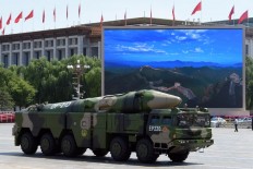 A military vehicle carries DF-21D missile past a display screen featuring an image of the Great Wall of China at Tiananmen Square in Beijing on Sept. 3, 2015, after a military parade to mark the 70th anniversary of victory over Japan and the end of World War II. 