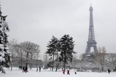  Skiers swish down snow-covered Paris streets 
