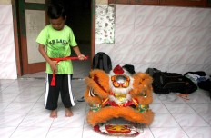 Secured: A barongsai dancer tightens his belt beside the iconic lion head. JP/ Maksum Nur Fauzan