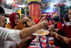 Semarang residents enjoy dinner at the tok panjang (long table) on the eve of Chinese New Year, locally known as Imlek. The main dishes are salad and fish. JP/Suherdjoko