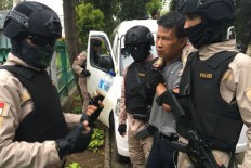 West Jakarta Police arrest an unidentified "angkot" (public minivan) driver near the Rawa Buaya railroad on suspicion of drunk driving and driving on the wrong side of the road on Feb. 27.