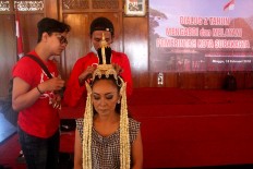 A female dancer is groomed by hairstylists. JP/Maksum Nur Fauzan