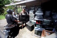 A customer comes to Sugeng’s workshop have his flat screen TV set repaired. JP/Boy T. Harjanto