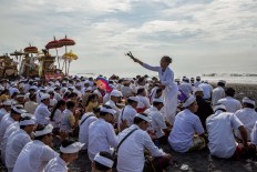 Sprinkle of water: A Balinese sprinkles holy water over participants of the Melasti ceremony at Lembeng Beach. JP/Agung Parameswara