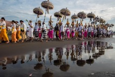 It takes a village: Balinese Hindus walk along Lembeng Beach in Gianyar during the Melasti purification ritual on March 14.JP/Agung Parameswara