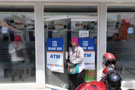 A state-owned lender Bank Rakyat Indonesia (BRI) customer comes out from a BRI ATM kiosk in Kediri, East Java on March 13.