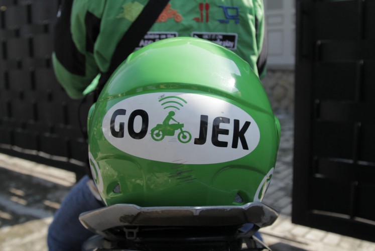Green helmet with Go-Jek logo.