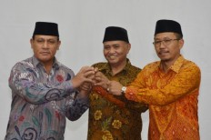 Corruption Eradication Commission (KPK) chairman Agus Rahardjo (center) hold hands with newly inaugurated law enforcement deputy Brig. Gen. Firli (left) and the KPK's prosecutor director Supardi (right) after Firli's inauguration at the KPK building in Jakarta on April 6, 2018. 