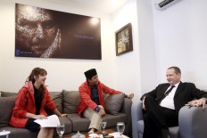 Indonesia Solidarity Party (PSI) executive board chairperson Tsamara Amany (left) and PSI secretary-general Raja Juli Antoni (center) speak with Secretary of the Russian Ambassador to Indonesia Sergey Drobyshevskiy at the PSI headquarters in Jakarta on April 11, 2018.
