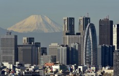 Japan's highest mountain, Mount Fuji at 3,776m (12,388 feet), is seen behind skyscrapers in Tokyo's Shinjuku area on November 28, 2015. Mount Fuji lies about 100 kilometres (60 miles) south-west of Tokyo, and can be seen from there on a clear day. 