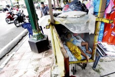 A trader’s child sleeps on the sidewalk. JP/Boy T. Harjanto

 